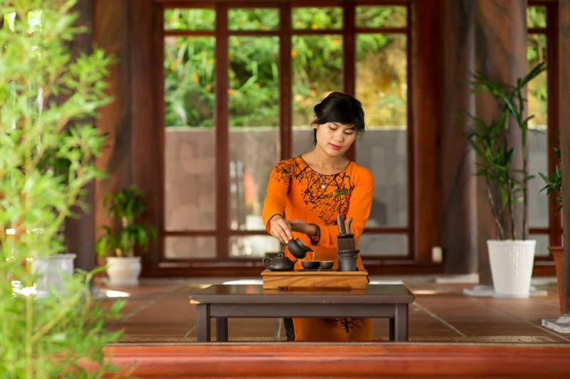 Vietnamese woman preparing tea in traditional setting at Ba Na Hills’ Tru Vu Tra Quan.