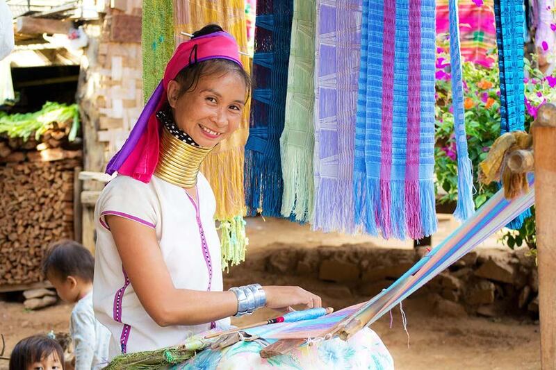 Karen woman with long neck adorned with golden necklaces in Chiang Mai village, Thailand