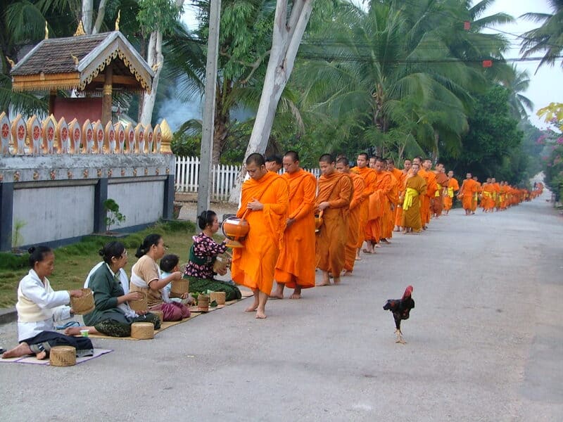 Tak Bat, the sacred alms of Theravāda monks, is widespread in Laos.